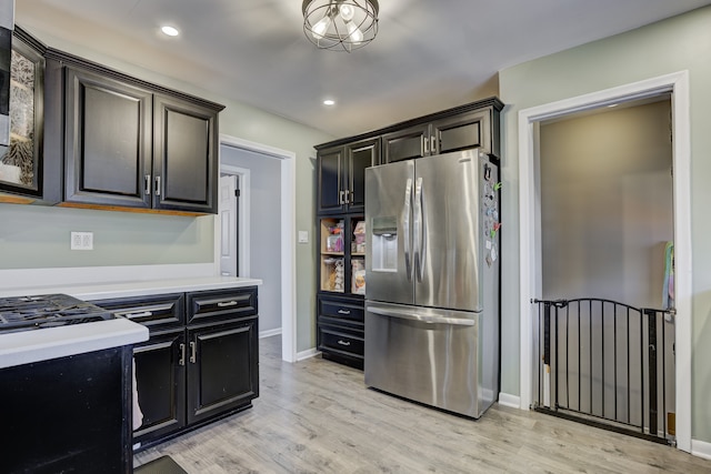 kitchen featuring light countertops, stainless steel fridge, light wood-style flooring, and recessed lighting