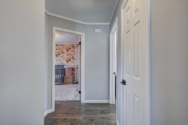 hall with ornamental molding, dark wood finished floors, and baseboards