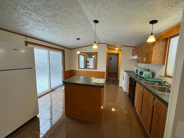 kitchen featuring a wainscoted wall, dark countertops, a kitchen island, a sink, and white appliances