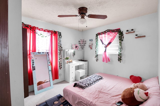 bedroom featuring ceiling fan, a textured ceiling, and light colored carpet