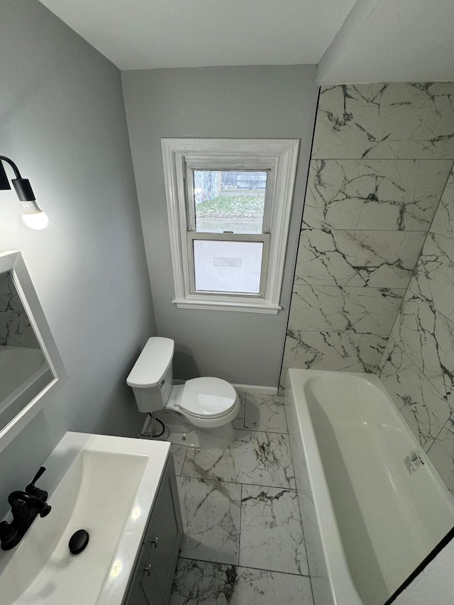 full bathroom featuring toilet, marble finish floor, a tub, and vanity