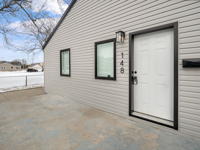 property entrance featuring a patio, fence, and driveway