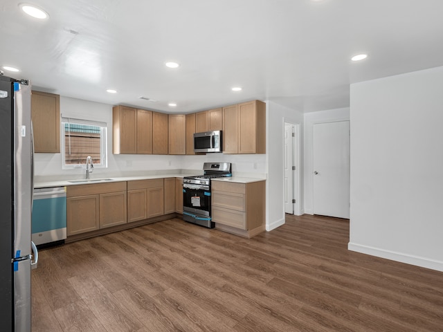 kitchen with stainless steel appliances, light countertops, a sink, and dark wood-style floors