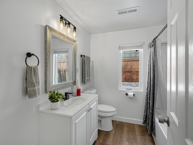 full bath with curtained shower, toilet, wood finished floors, vanity, and visible vents