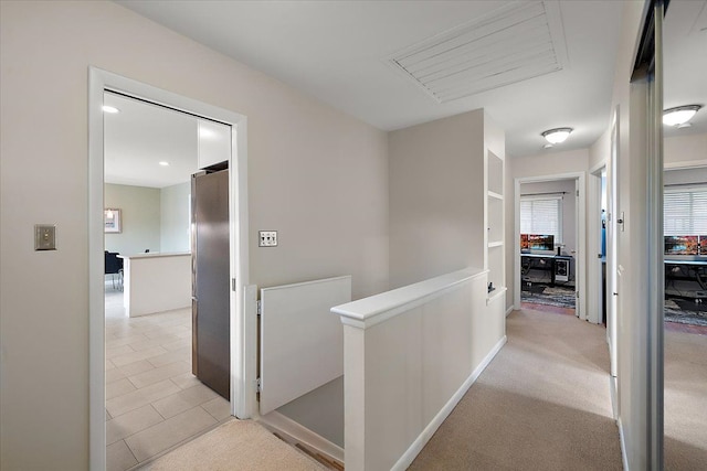 corridor with light carpet, baseboards, and an upstairs landing