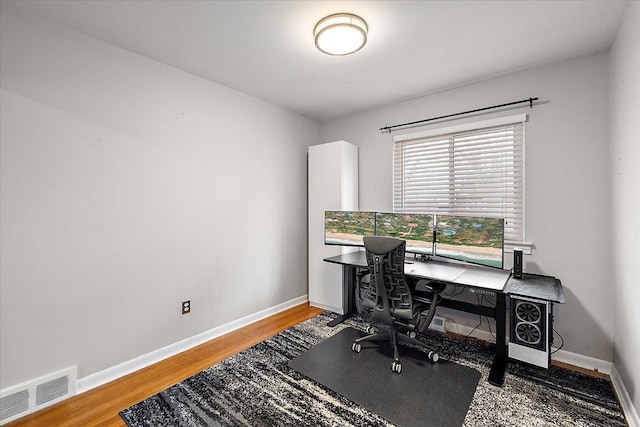 office space featuring visible vents, baseboards, and wood finished floors