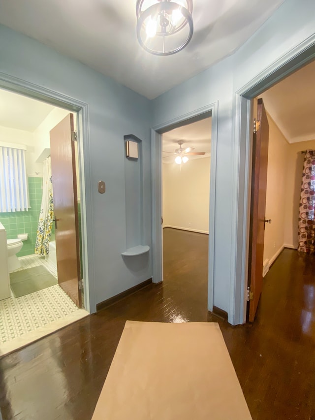 corridor with wood finished floors and baseboards