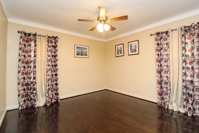 empty room featuring ceiling fan, wood finished floors, and baseboards