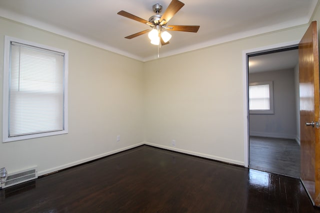 unfurnished room featuring a ceiling fan, wood finished floors, visible vents, and baseboards