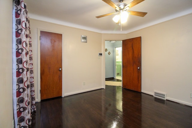 unfurnished room with wood finished floors, visible vents, and baseboards