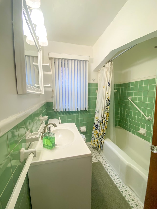 bathroom featuring shower / tub combo, a wainscoted wall, tile walls, and vanity