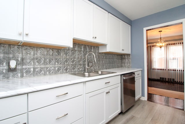 kitchen with decorative backsplash, white cabinets, dishwasher, light wood-style floors, and a sink