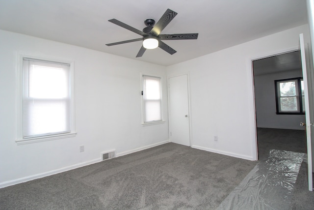 unfurnished room featuring a ceiling fan, carpet, visible vents, and baseboards