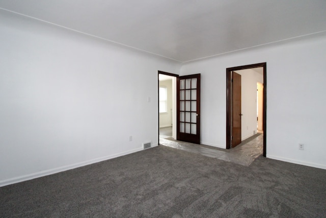 carpeted spare room featuring visible vents and baseboards