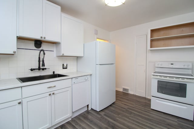 kitchen with dark wood finished floors, visible vents, backsplash, a sink, and white appliances