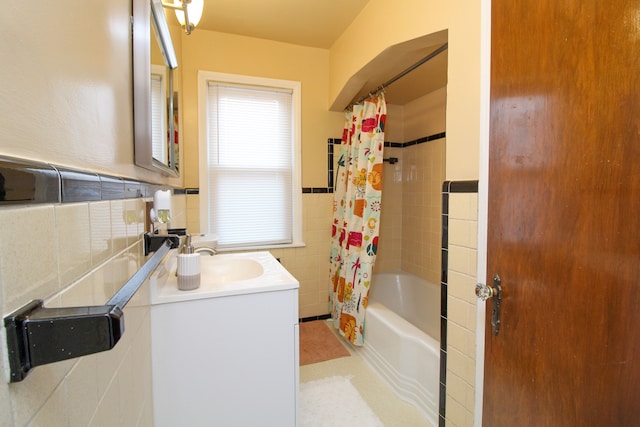 full bathroom featuring a wainscoted wall, shower / bath combo, tile walls, and vanity