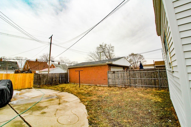 view of yard featuring a patio, an outdoor structure, and a fenced backyard