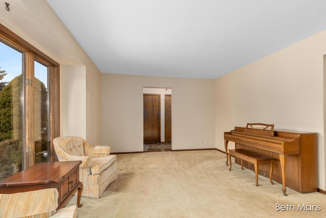 sitting room featuring light colored carpet and baseboards