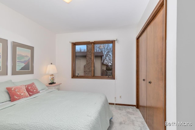 bedroom with carpet floors, baseboards, and a closet