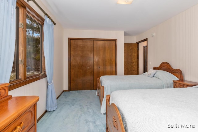 bedroom with light carpet and a closet