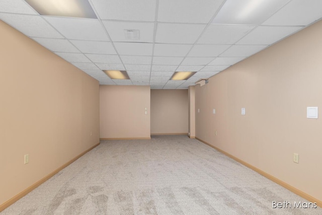 carpeted empty room featuring a drop ceiling, visible vents, and baseboards