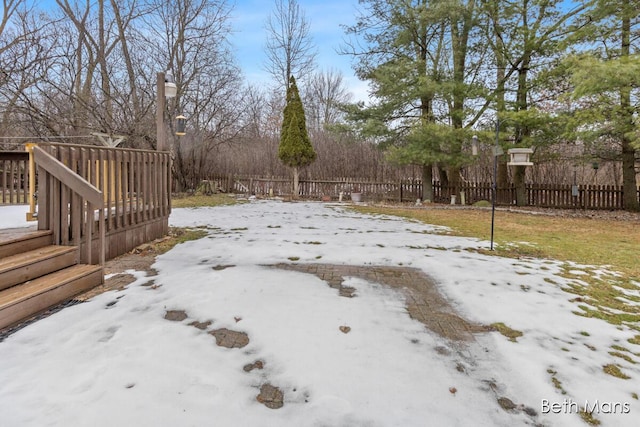 yard covered in snow featuring fence