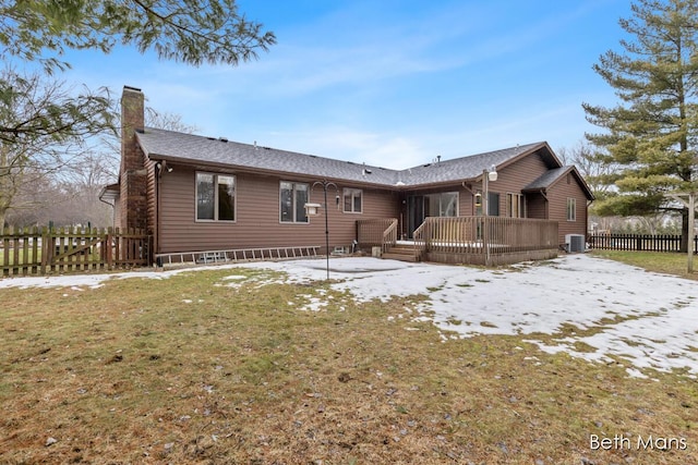 view of front of house featuring a chimney, a front yard, central AC, fence, and a deck