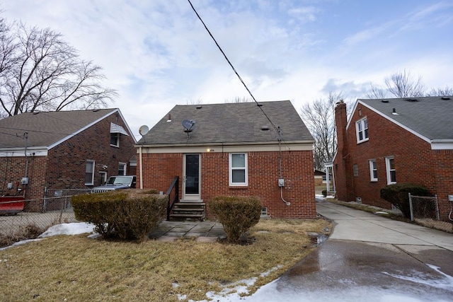 back of house with a yard, brick siding, and fence