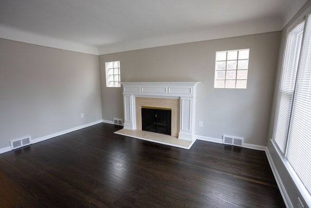 unfurnished living room featuring a healthy amount of sunlight, visible vents, and a fireplace