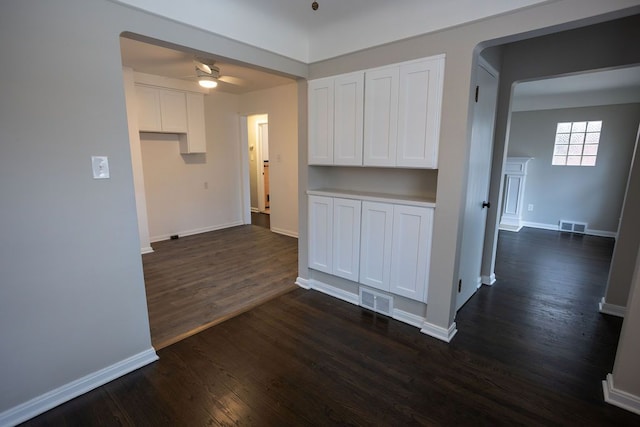 kitchen with a ceiling fan, baseboards, visible vents, white cabinetry, and dark wood finished floors