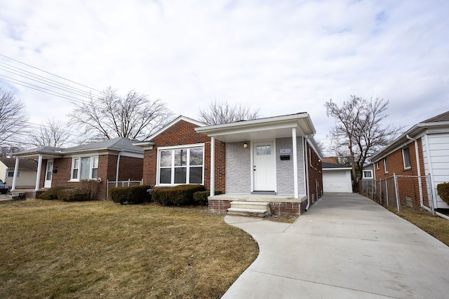 view of front of house featuring an outbuilding, covered porch, fence, a front yard, and brick siding