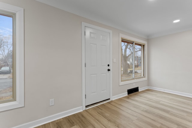 foyer featuring baseboards, recessed lighting, and light wood-style floors