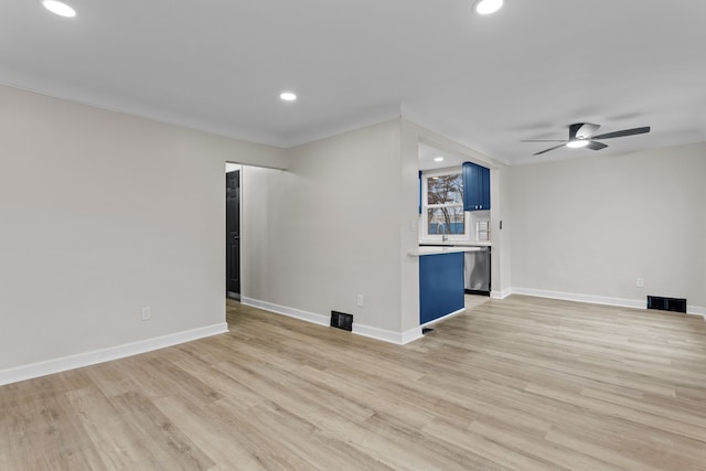 unfurnished living room with light wood-style flooring, visible vents, and baseboards