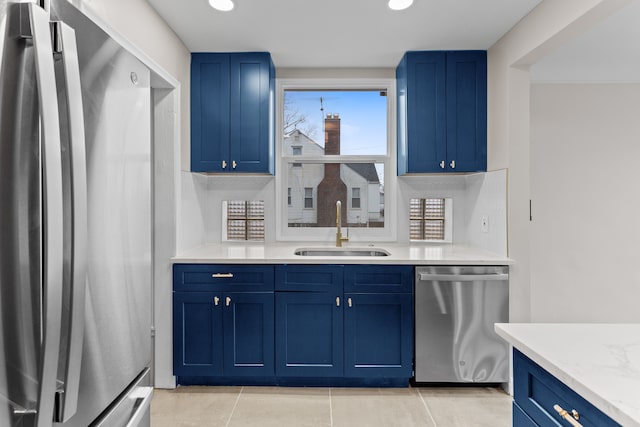 kitchen with light tile patterned flooring, stainless steel appliances, blue cabinetry, a sink, and recessed lighting