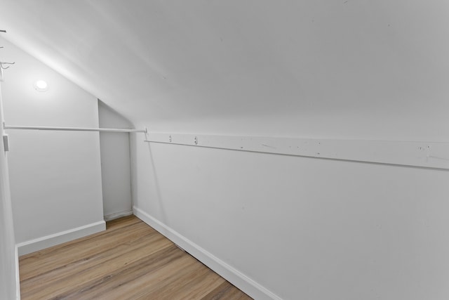 additional living space with lofted ceiling, baseboards, and wood finished floors