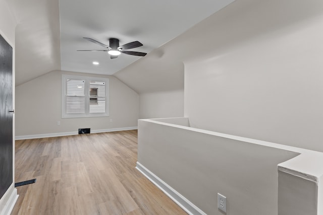 bonus room featuring light wood-style floors, vaulted ceiling, baseboards, and a ceiling fan