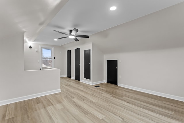 empty room with recessed lighting, light wood-style flooring, vaulted ceiling, ceiling fan, and baseboards