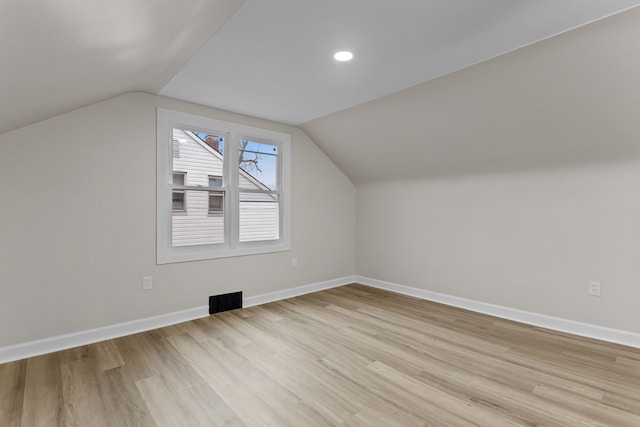 bonus room with lofted ceiling, light wood finished floors, and baseboards