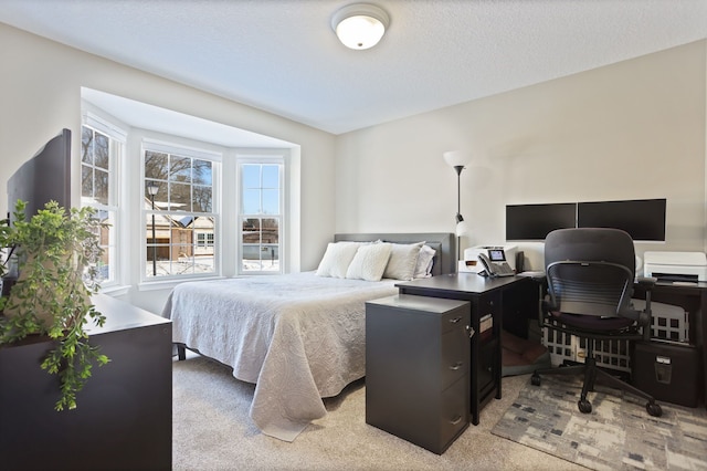 bedroom featuring a textured ceiling and light colored carpet