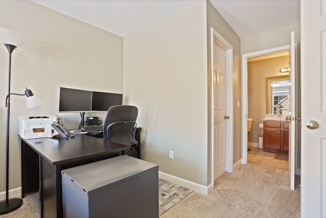 office space featuring light carpet, a textured ceiling, and baseboards