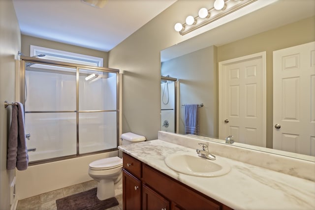 bathroom with vanity, toilet, and bath / shower combo with glass door