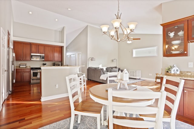 dining space with high vaulted ceiling, recessed lighting, light wood-type flooring, and a notable chandelier