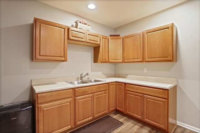 kitchen featuring light wood-style floors, recessed lighting, light countertops, and a sink