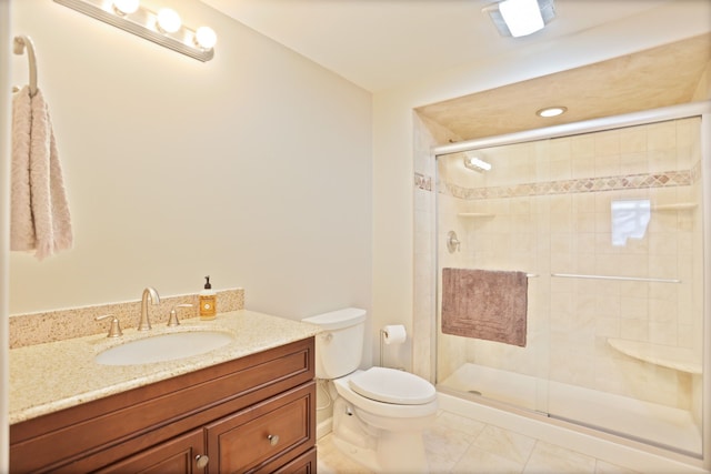 bathroom featuring a stall shower, tile patterned flooring, vanity, and toilet