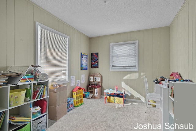 playroom featuring carpet floors and a textured ceiling