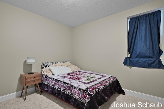 bedroom with carpet floors, a textured ceiling, and baseboards