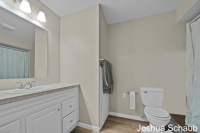 full bathroom featuring toilet, wood finished floors, vanity, visible vents, and baseboards