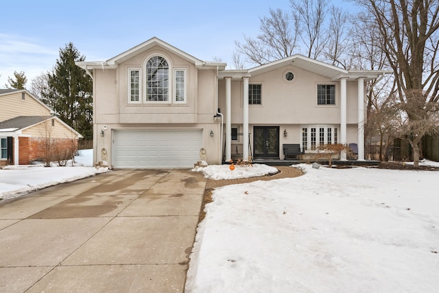 view of front of home with a garage, concrete driveway, and stucco siding