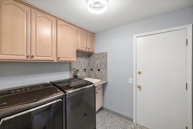 laundry area with cabinet space, a sink, and independent washer and dryer