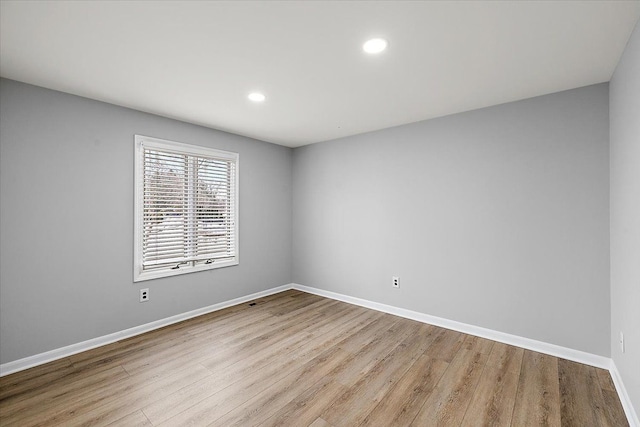 spare room with recessed lighting, wood finished floors, and baseboards